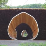 Wie eine riesige Urzelle liegt die für die Landesgartenschau neu konstruierte Sole Arena im Zentrum der Stadt Bad Essen. Der im Grundriss gerundet-dreieckige Körper ist aus Reisigkonstruktionen aufgebaut und von luftigen Öffnungen durchbrochen – gleichermaßen schön und einmalig. Umgeben von tröpfelnden Reisigwänden finden die Besucher Ruhe und Entspannung auf Sitzbänken rund um eine Brunnenschale und inhalieren dort die fein vernebelte Sole.
